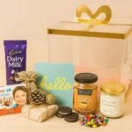 Premium bow basket hamper with chocolates, greeting card, and snacks.