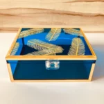Neon blue Feather Print Box with golden feather motifs and gold frame, closed view.