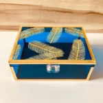 Neon blue Feather Print Box with golden feather motifs and gold frame, closed view.