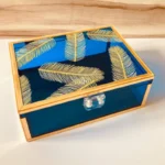 Angled view of neon blue Feather Print Box with gold detailing.