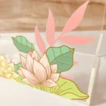 Close-up of lotus flower print on clear acrylic bag surface.