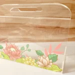 Side view of floral printed acrylic horizontal bag with handle.