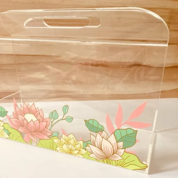 Side view of floral printed acrylic horizontal bag with handle.
