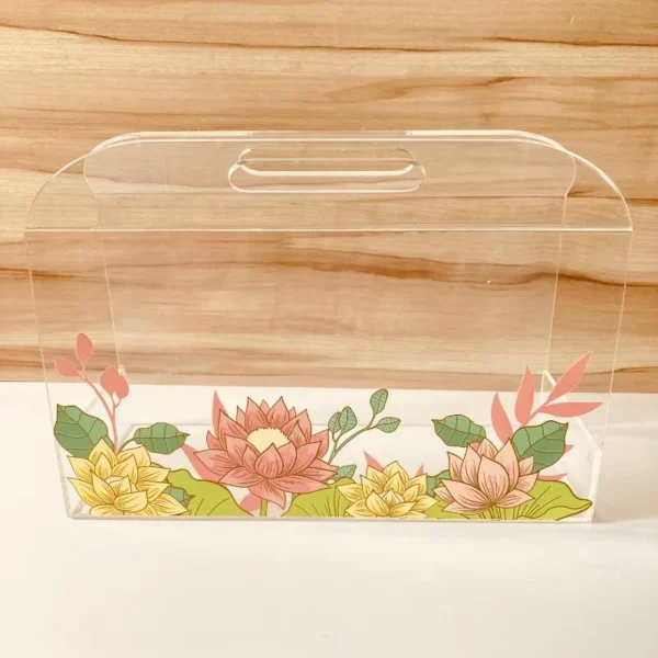Transparent acrylic horizontal bag with multicolor lotus floral print, front view.