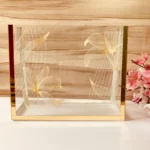 Printed Cross Bag in clear acrylic with golden floral prints, front view.