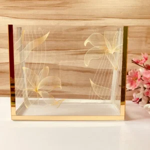 Printed Cross Bag in clear acrylic with golden floral prints, front view.