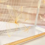 Close-up of golden floral prints on Printed Cross Bag surface.