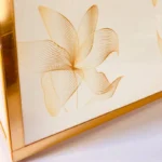 Close-up of golden floral patterns on Cross Bag surface.