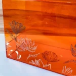 Close-up of lotus flower detailing on acrylic bag surface.