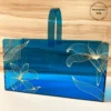 Blue acrylic long basket with golden floral print, front view.