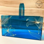 Blue acrylic long basket with golden floral print, front view.