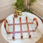 Top view of grid-style acrylic tray with brown stitched leather strips.