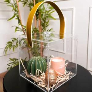 Side angle of clear cube gift box showcasing mustard leather handle and contents.